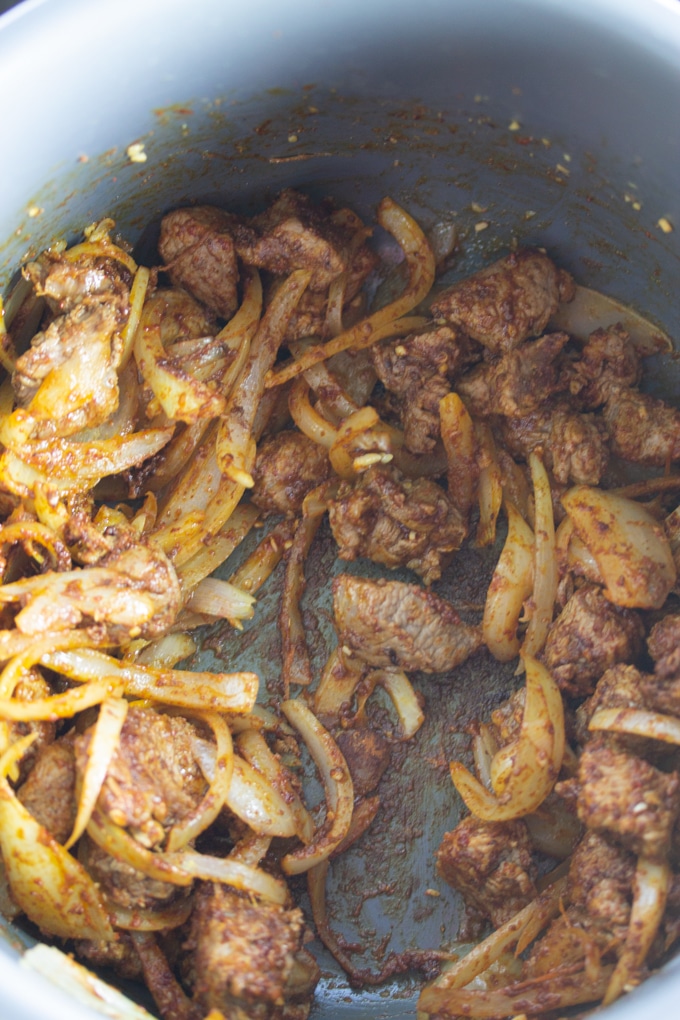 lamb and onions and garlic with spices in pressure cooker