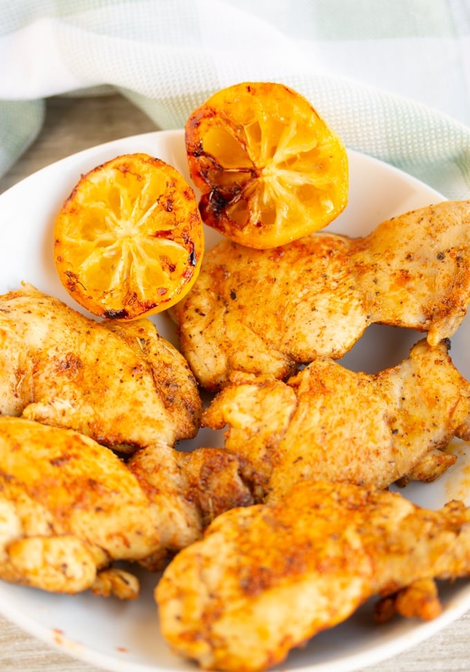 air fryer lemon pepper chicken thighs on a white plate
