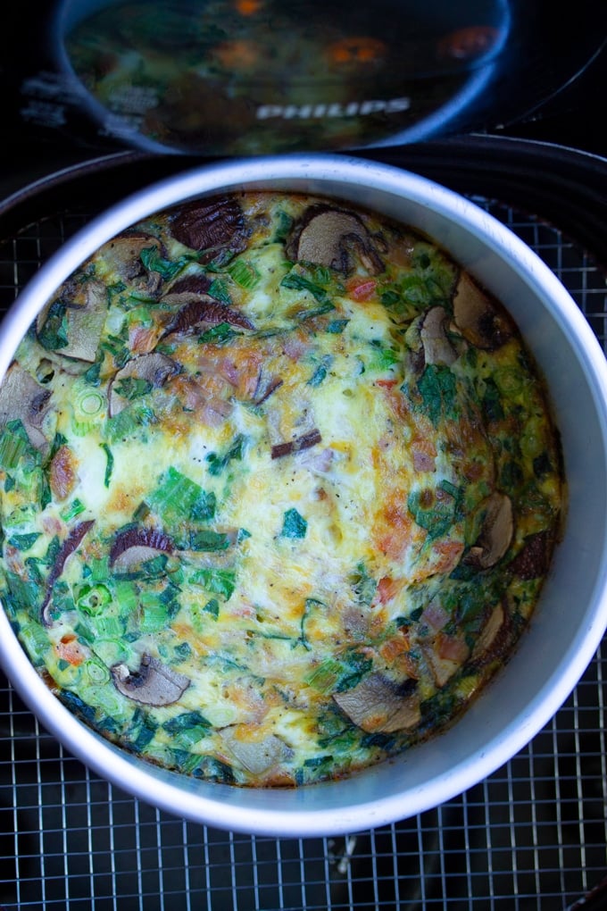 This Air Fryer Egg Frittata is a delicious breakfast recipe for your Air Fryer. Quick, easy, and healthy. #airfryerbreakfast #airfryerrecipe #breakfastrecipe #airfried air fryer egg frittata in air fryer basket