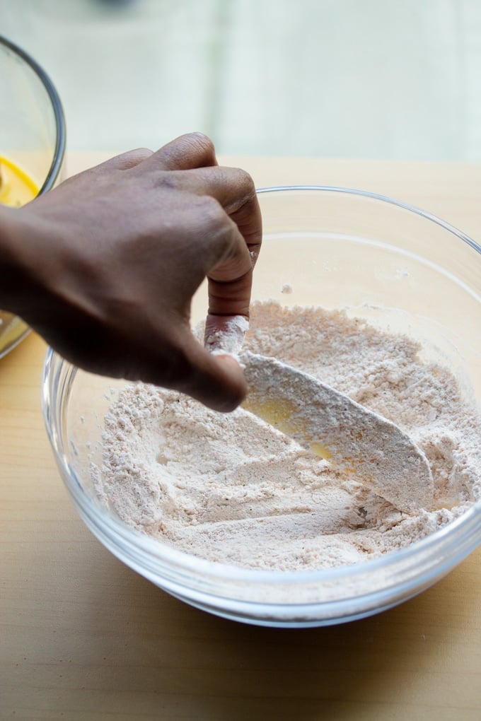 hand placing potato wedge in flour