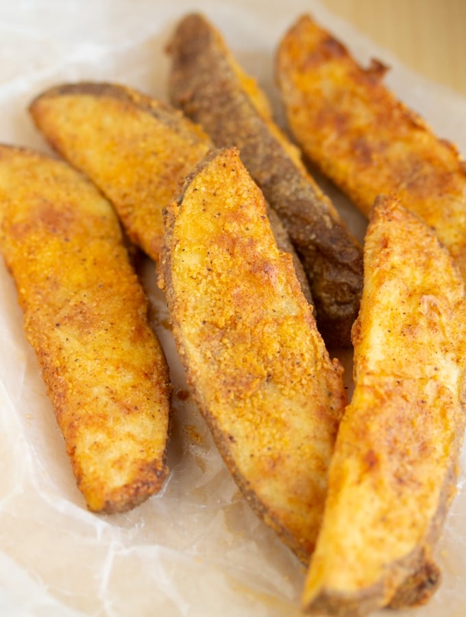 These Copycat KFC Potato Wedges are made in the Air Fryer! They are perfectly seasoned and the perfect side dish to your favorite meal. I’ve provided full step by step instructions so you can make a healthier version of these copycat KFC fries. #copycat #copycatrecipe #airfryerrecipe #airfryerfries #airfryerwedges air fryer potato wedges in a pile