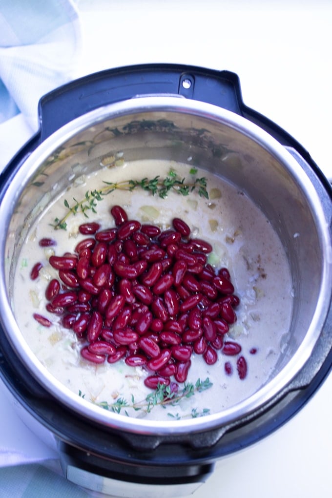 ingredients for Instant Pot Rice and Beans in the Instant Pot with the kidney beans layered on top