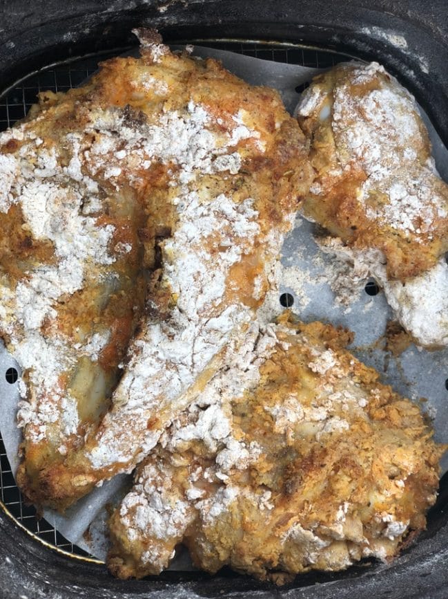 chicken pieces covered in flour in Air fryer basket