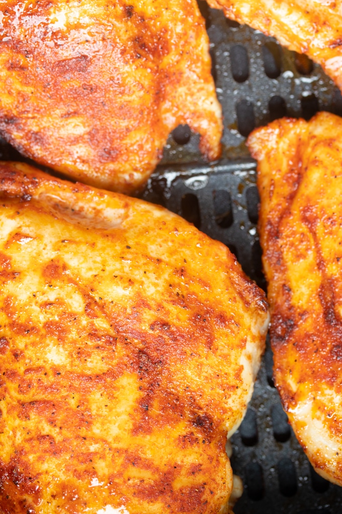 close up of chicken breast in air fryer basket