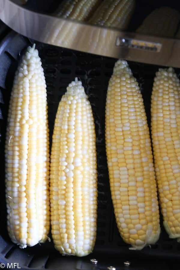 corn on the cob in a single layer in air fryer basket 