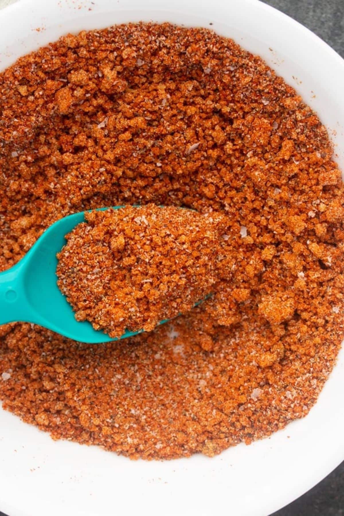 Make homemade bbq seasoning from scratch! Use as a dry rub or just a seasoning for chips. Only 7 ingredients for the perfect spice rub. #bbq #barbeque #homemadespicemixtures bbq seasoning in bowl with spoon sticking into it from left