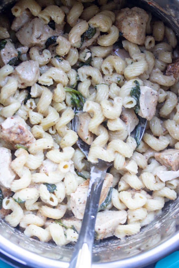 completed creamy cajun chicken pasta in pressure cooker with spoon sticking out