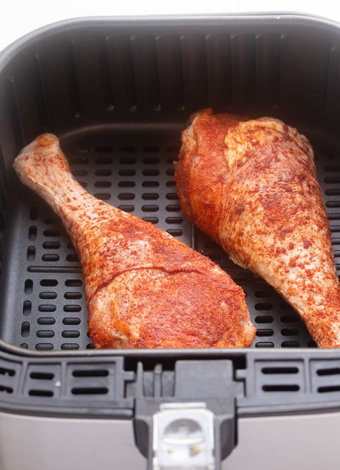 raw seasoned turkey legs in air fryer basket