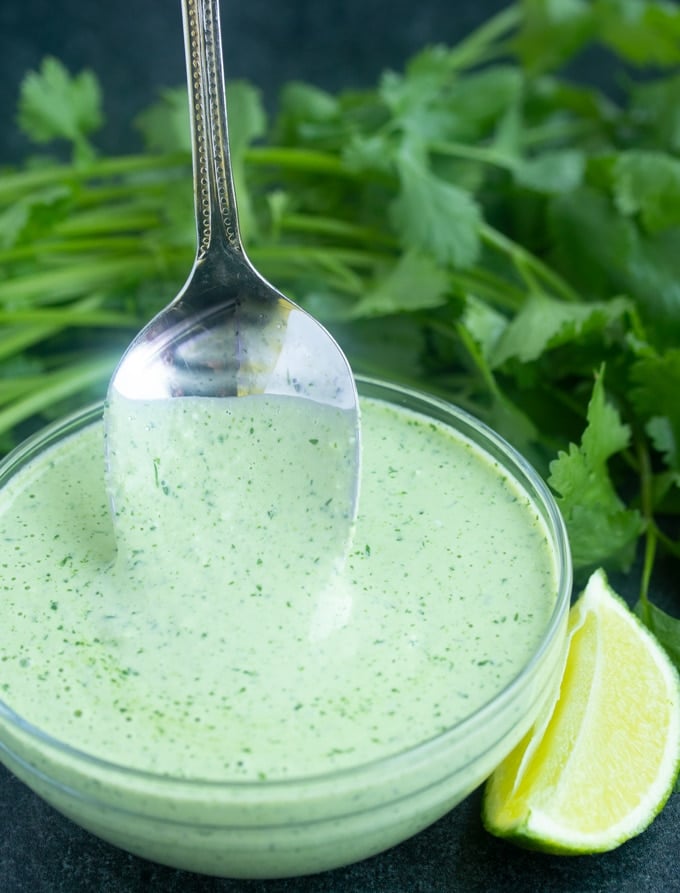 Peruvian green sauce with spoon sticking out of it