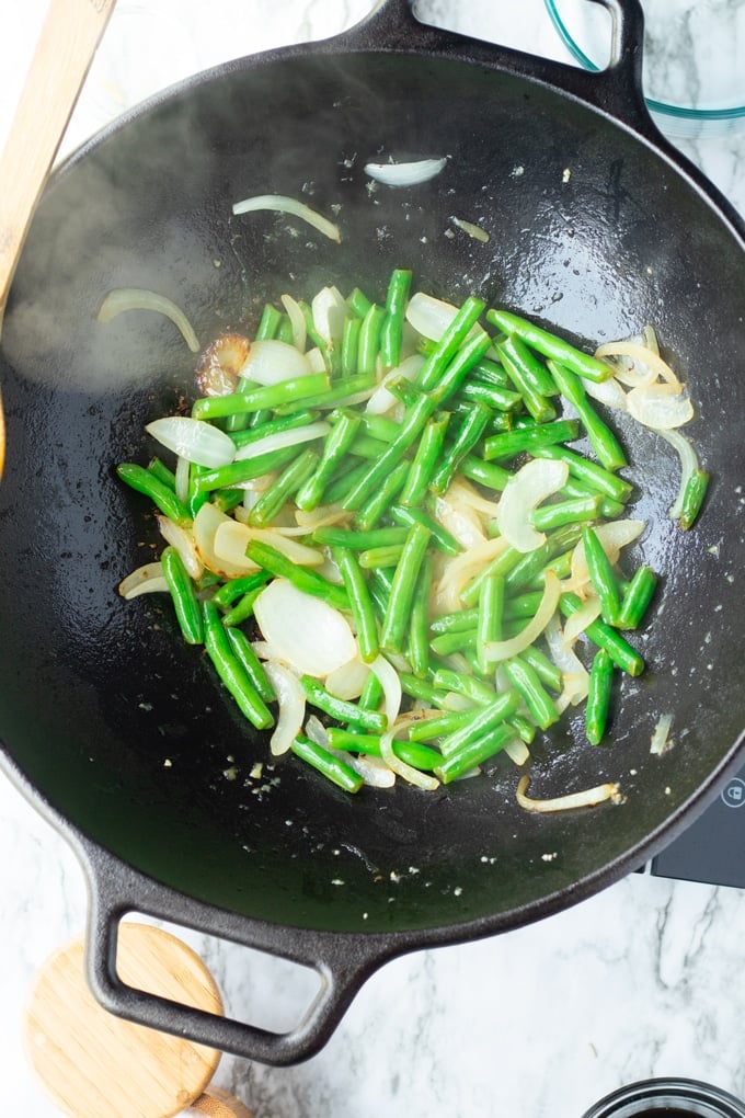 onions and green beans in wok