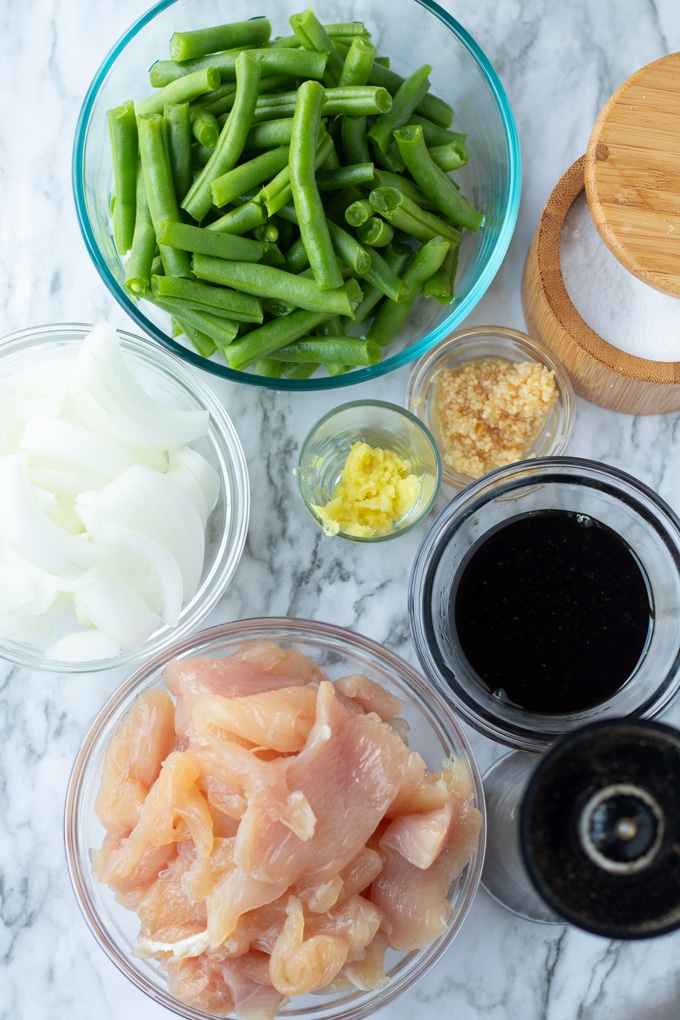 green beans, salt, garlic, giner, onions, sauce, and chicken in small bowls