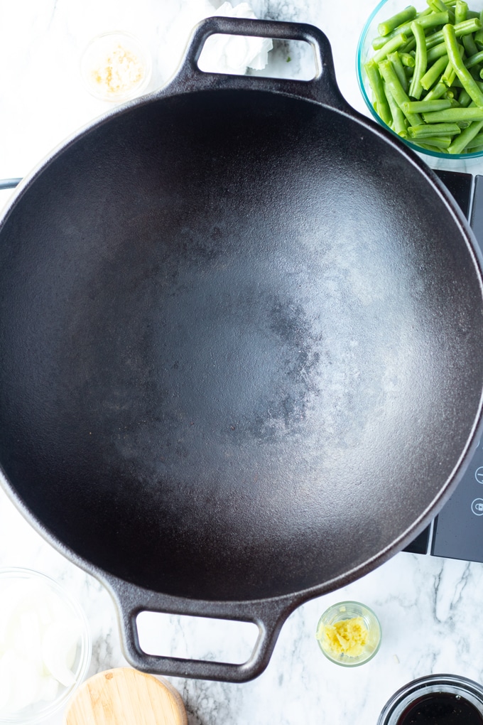 cast iron wok with green beans on the side