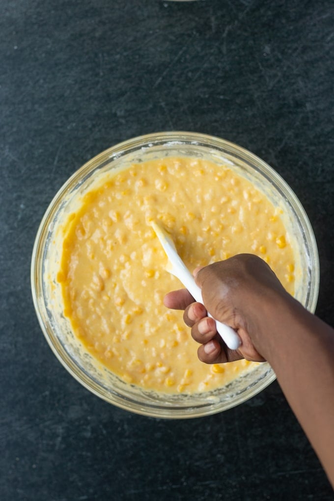 ingredients being stirred in bowl with hand sticking out