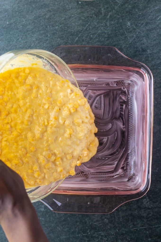 corn souffle ingredients being poured into casserole dish