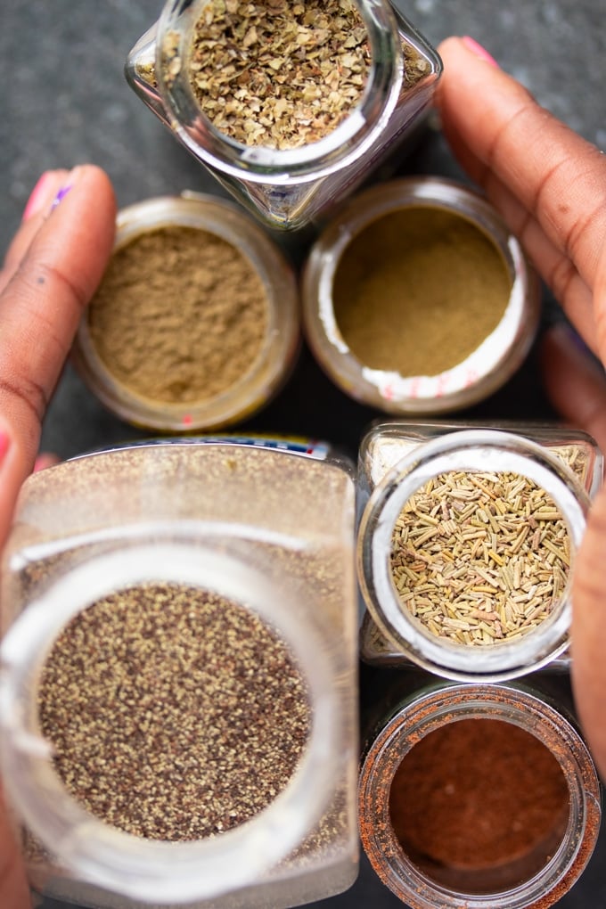 spices in jars with hands surrounding them