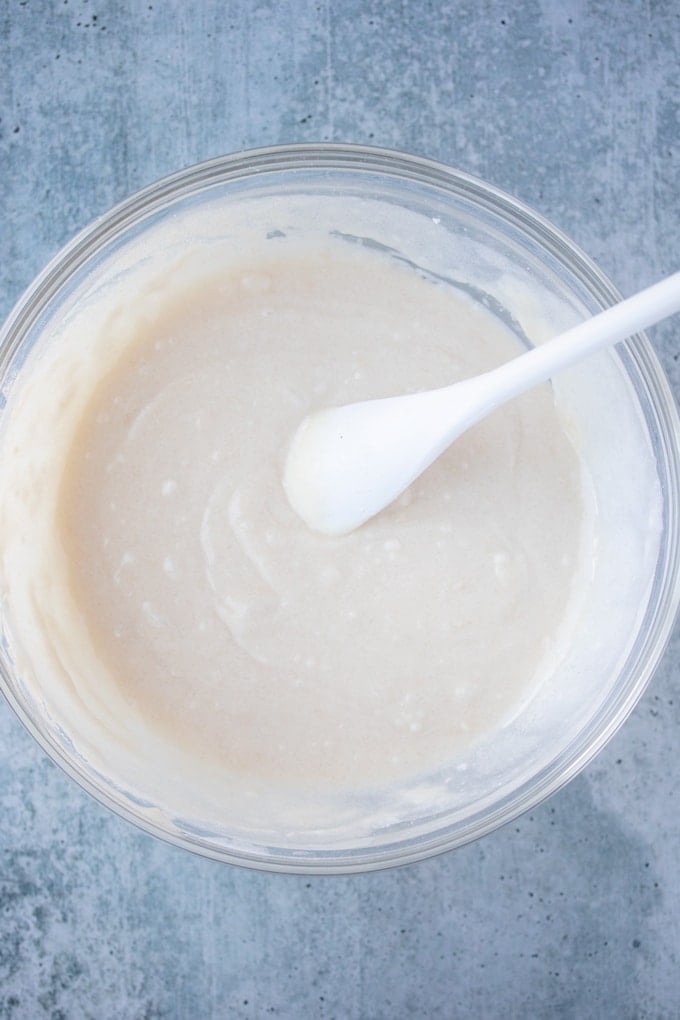 cake topping for southern peach cobbler mixed in a glass bowl with white spoon sticking out