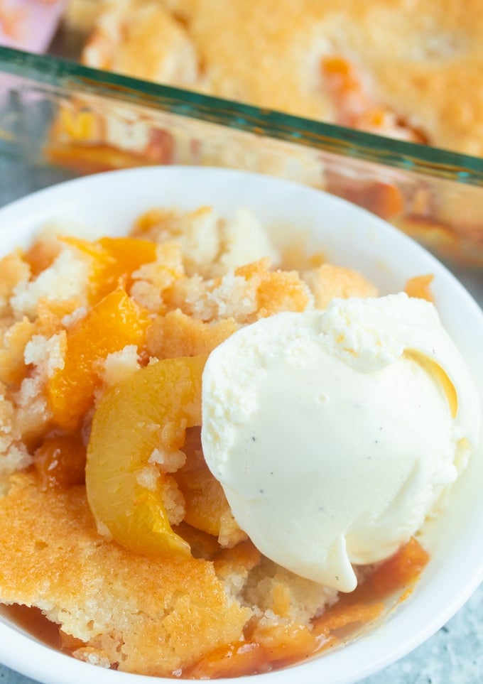 southern peach cobbler on a plate with vanilla ice cream on top