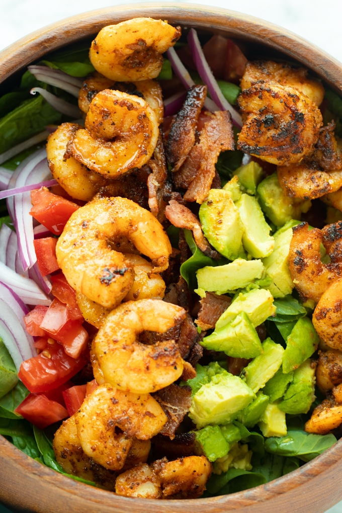 shrimp salad with spinach, shrimp, bacon and avocado in bowl