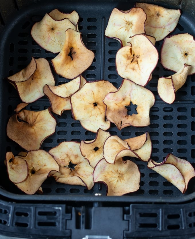 air fryer apple chips laying in air fryer basket