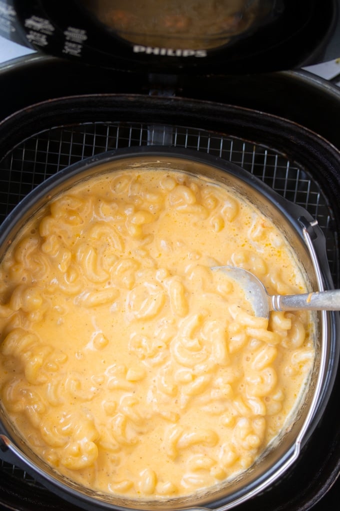 air fryer mac and cheese in basket with spoon sticking out of macaroni