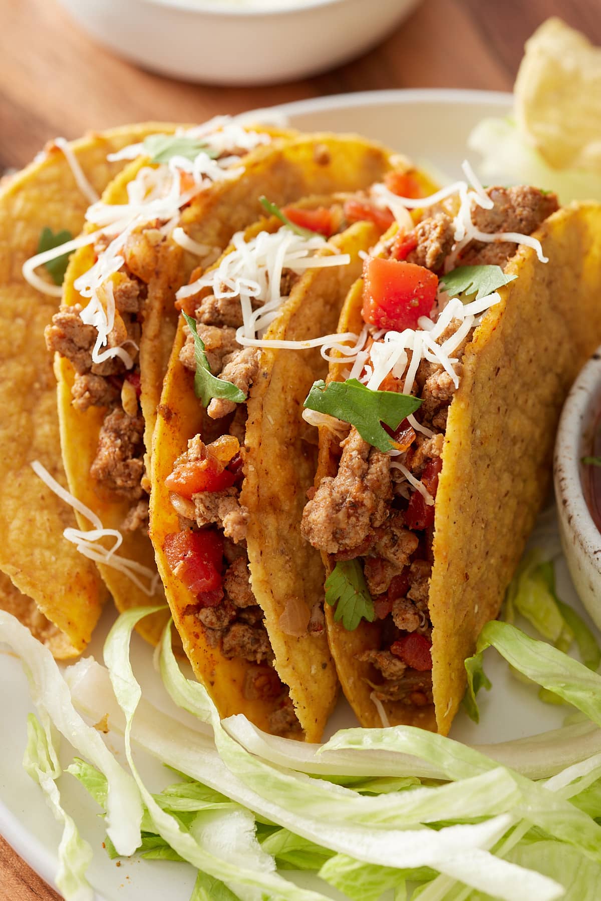 gorund turket taco meat in hard shells topped with cheese and cilantro