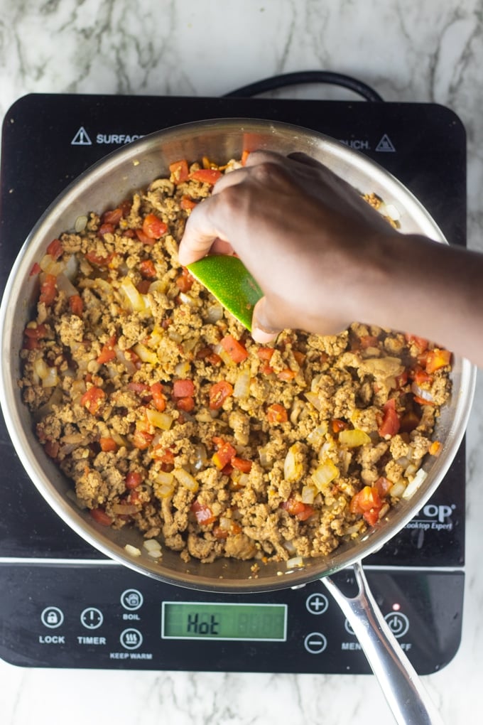 hand squeezing lime over ground turkey taco meat