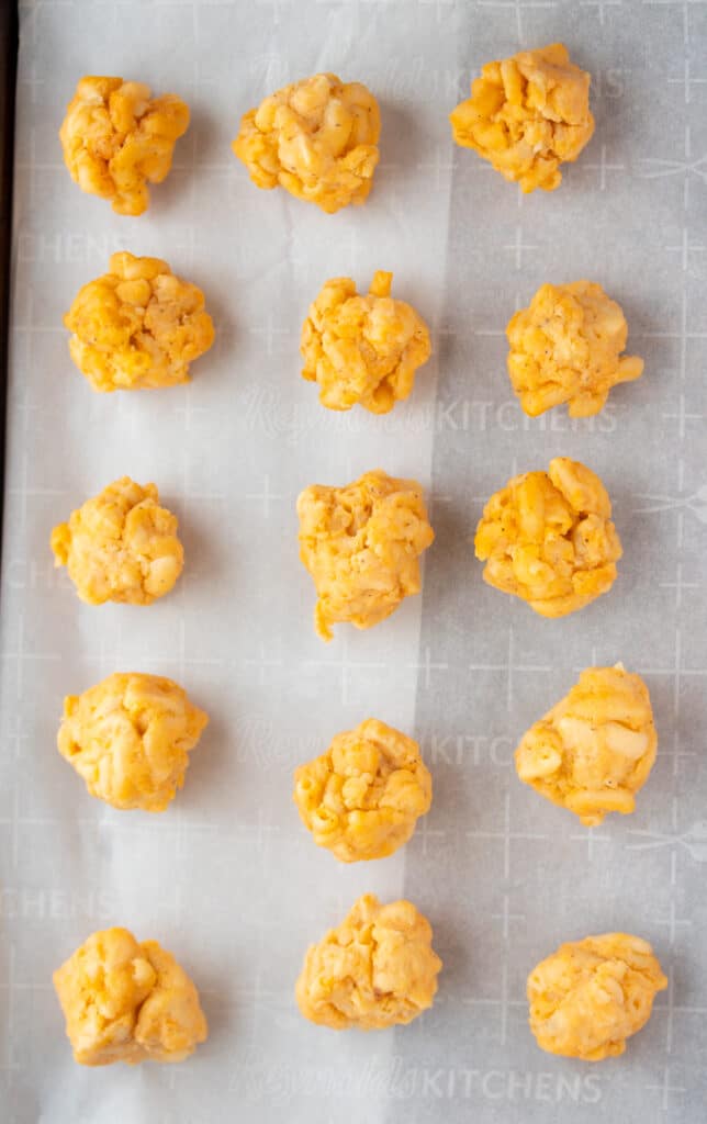 rolled up macaroni balls on a baking sheet