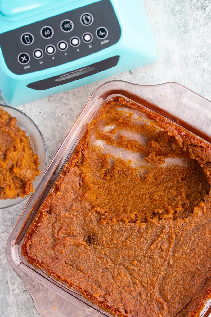 half eaten sweet potato pudding in baking dish with blender to the side 