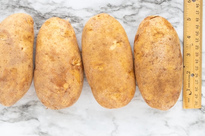 raw potatoes next to a ruler