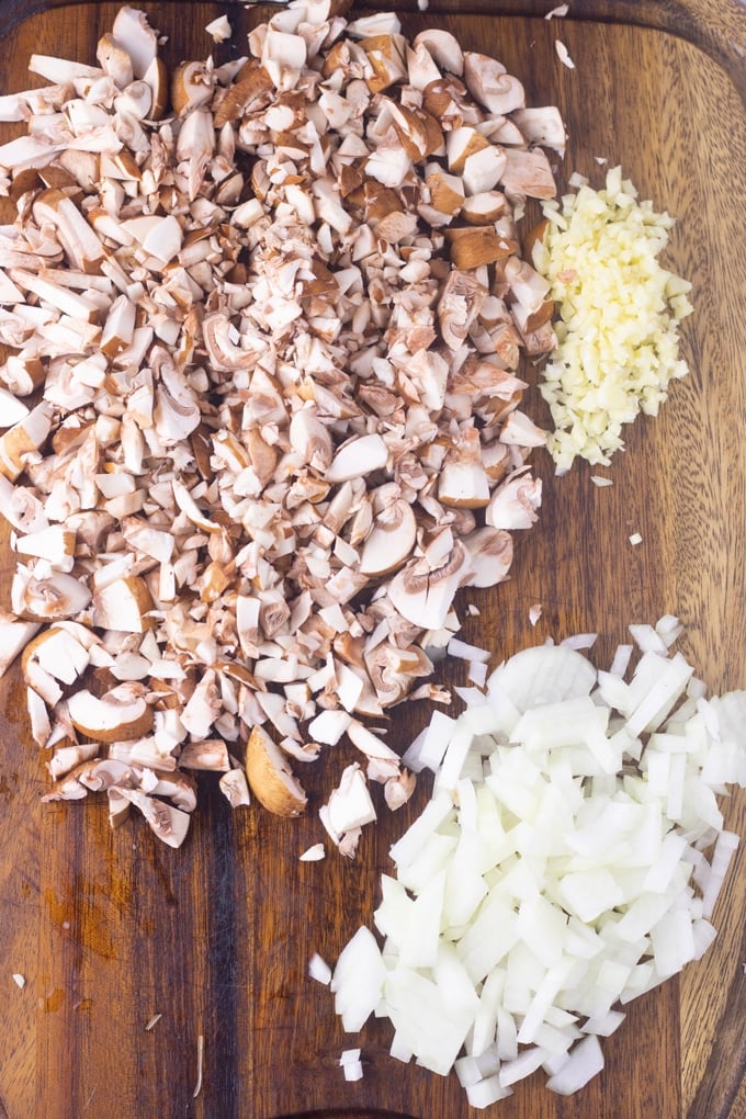 mushrooms, onions, and garlic on a cutting board