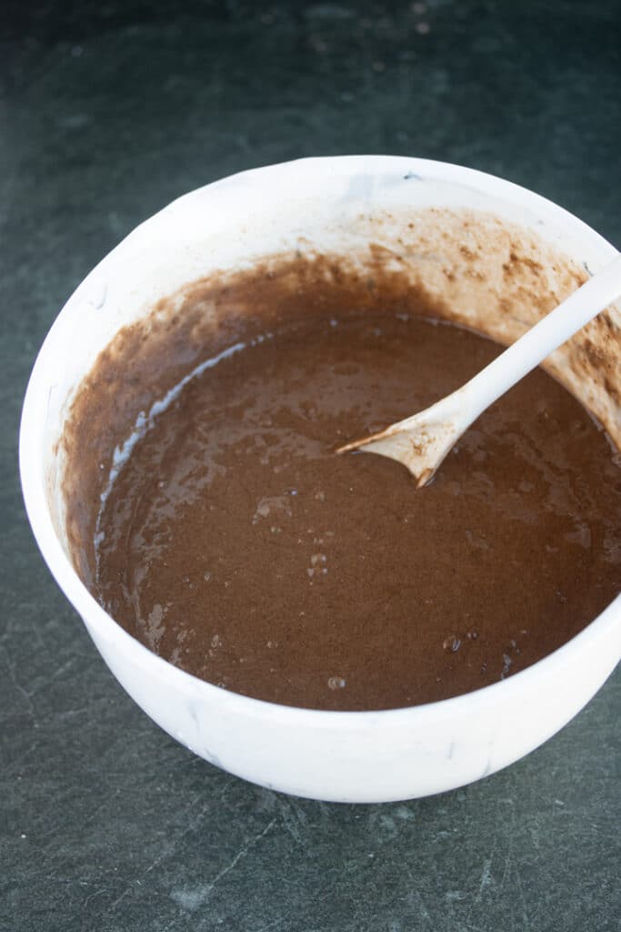 mixed cake batter with white spoon sticking out of bowl