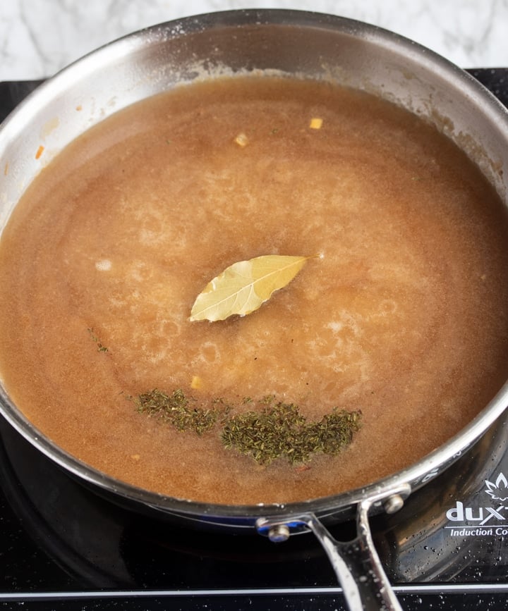 gravy in skillet with bay leaf and dry thyme