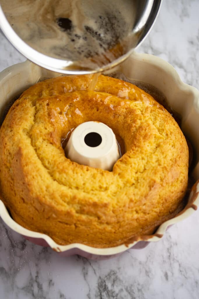 rum cake glaze being poured over cake