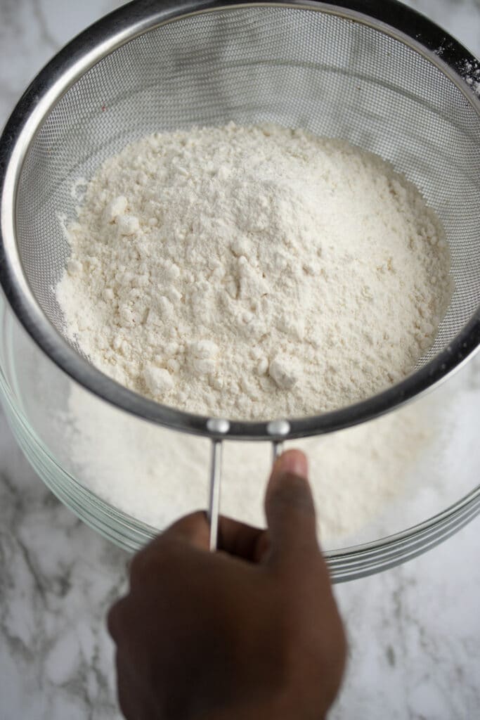 flour and vanilla pudding being sifted over bowl