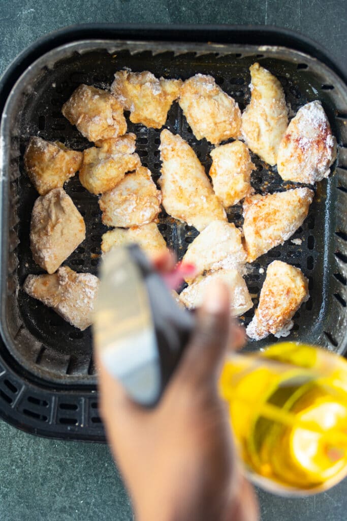 chicken in basket with spray bottle over basket