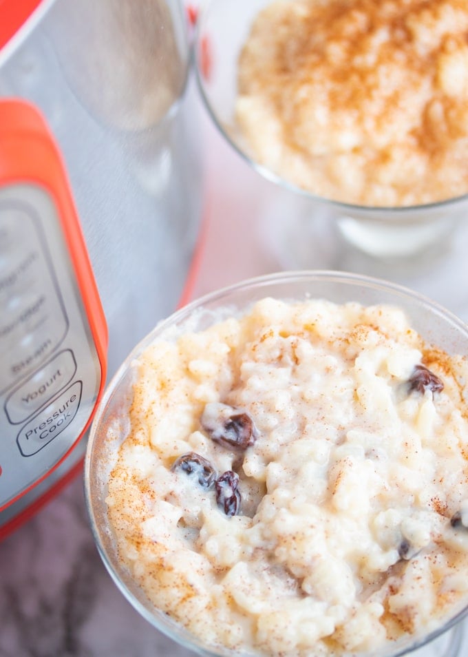 rice pudding with raisins in glass in front of instant pot