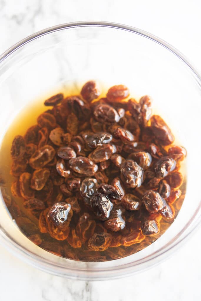 raisins soaking in bourbon in a glass bowl