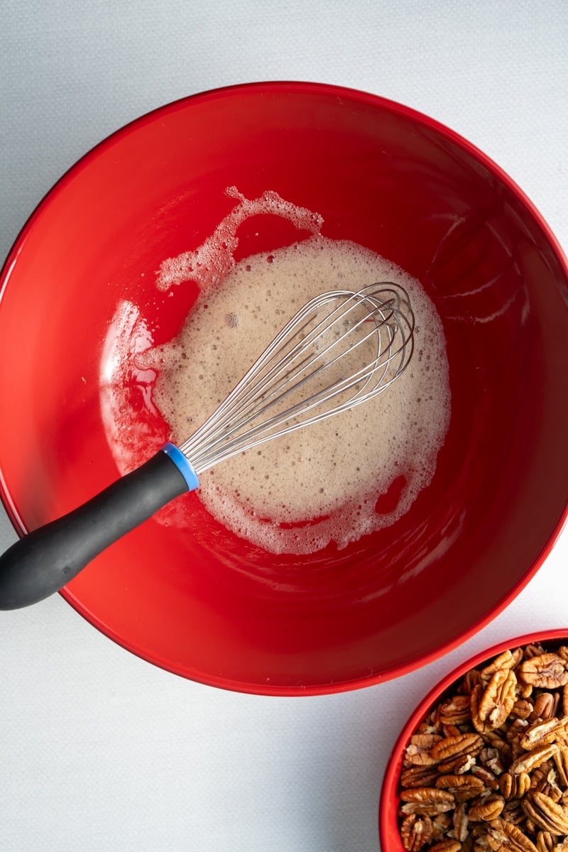 egg white, water, and vanilla extract in bowl that has been whisked