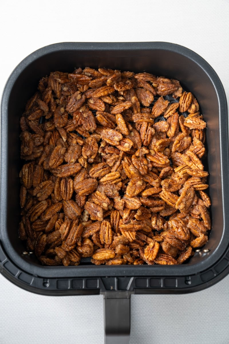 cinnamon sugar pecans in air fryer basket before air frying