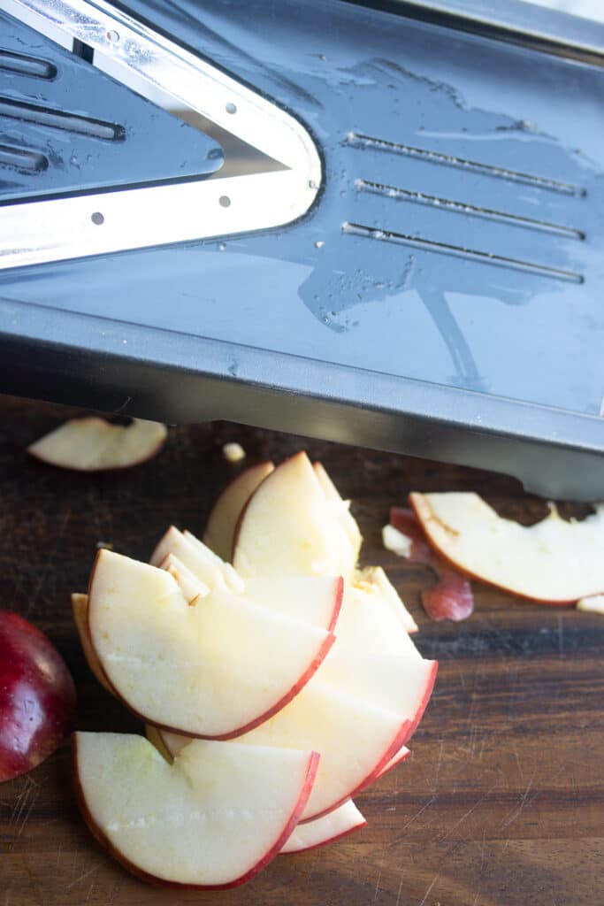 apple slices in front of a black mandolin