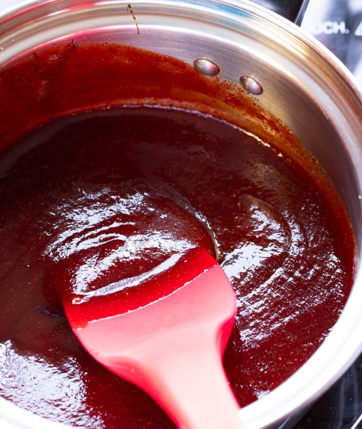 bbq sauce in glass bowl with spoon sticking out