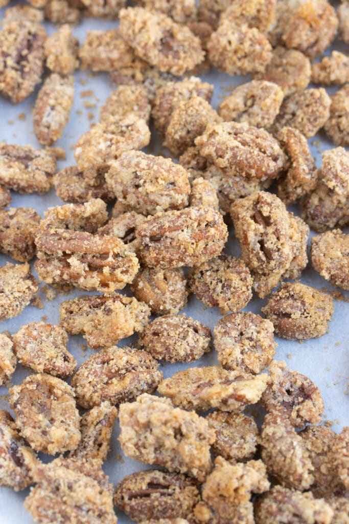 suagred pecans spread out on parchment paper