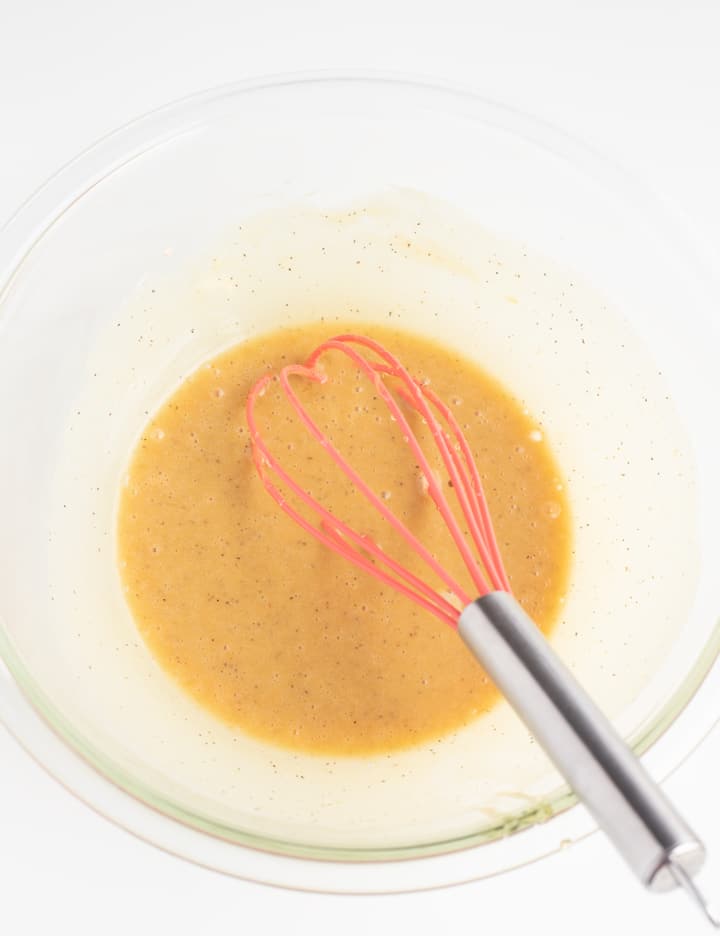 honey mustard sauce in glass bowl with whisk sticking out