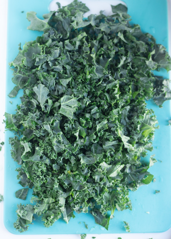 chopped kale on teal cutting board