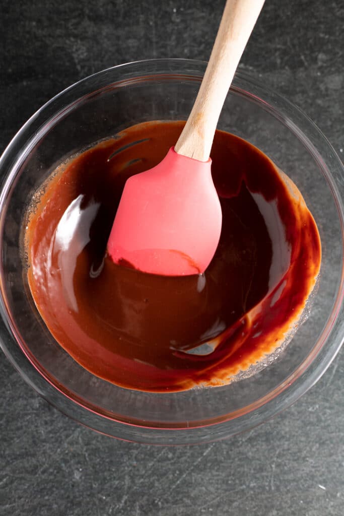 melted chocolate in a glass bowl with spatula sticking out