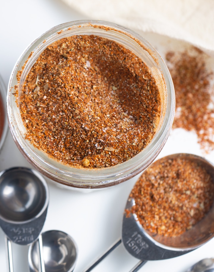 taco seasoning in jar with measuring surrounding it