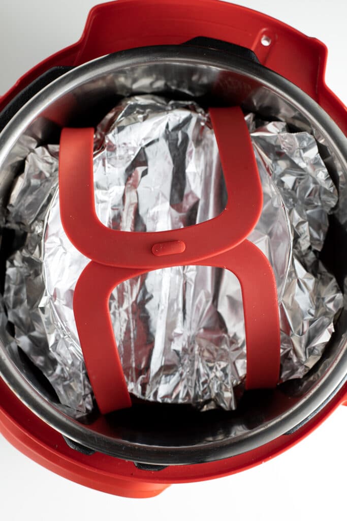 dish covered with foil on bakeware sling inside of instant pot