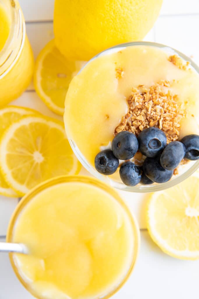 lemon curd in jars with granola and blueberries in photo