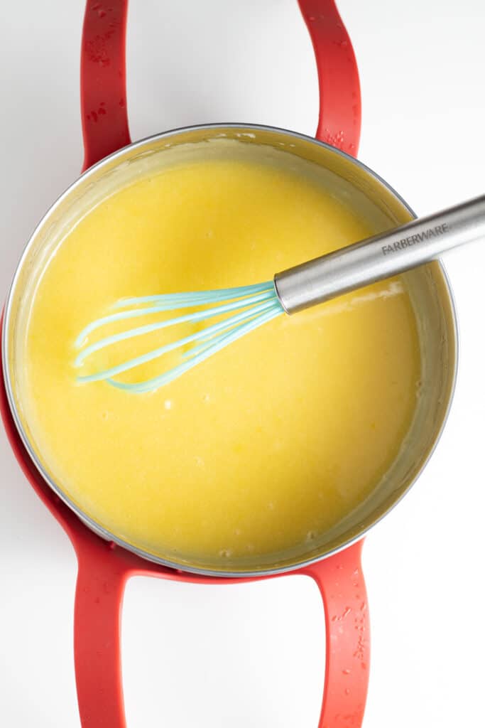lemon curd in steel pan with whisk sticking out