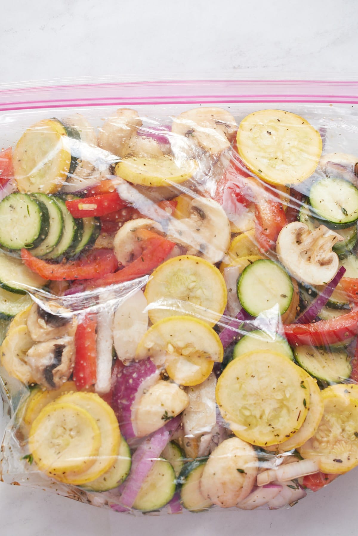 The vegetables and marinade in a glass bowl